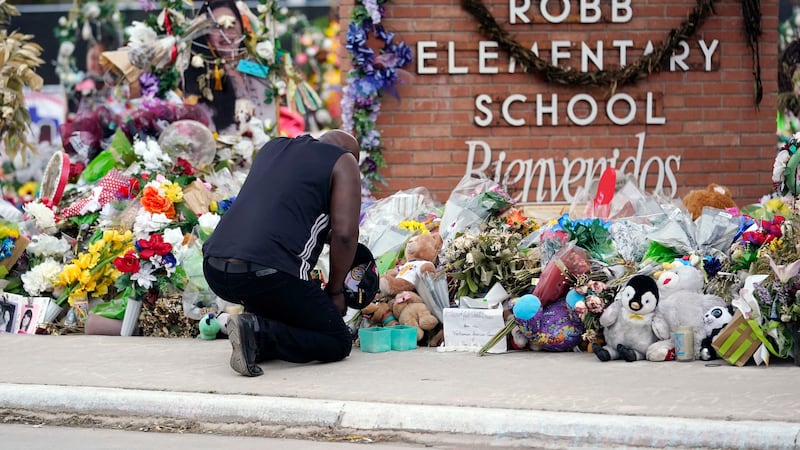 FILE - Reggie Daniels pays his respects a memorial at Robb Elementary School, June 9, 2022, in...