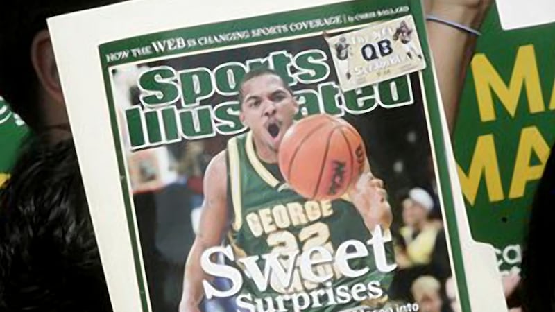 FILE - A George Mason University fan holds up the cover of Sports Illustrated magazine at a...