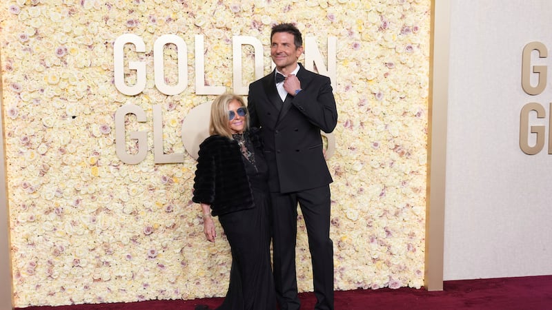 Gloria Campano, left, and Bradley Cooper arrive at the 81st Golden Globe Awards on Sunday,...