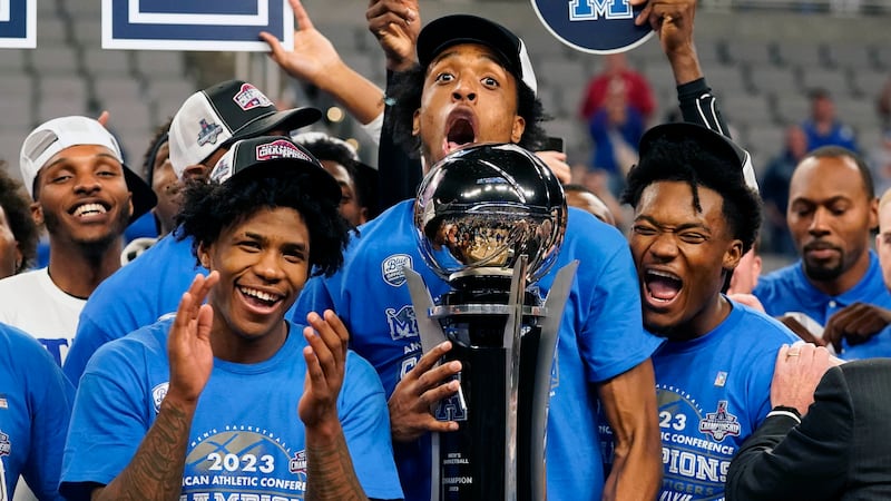 Memphis forward DeAndre Williams, center, holds the winners trophy with teammates Kendric...