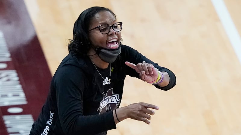 Mississippi State coach Nikki McCray-Penson lowers her mask as she calls to players during the...