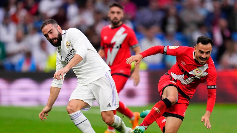 Real Madrid's Dani Carvajal, left, and Rayo's Alvaro Garcia challenge for the ball during a...