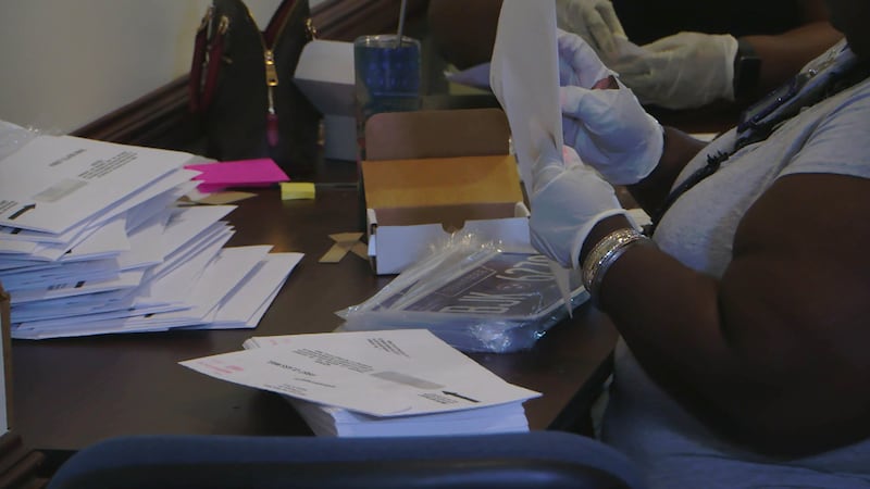 Shelby County Clerk's Office employees work to give out new tags to drivers.