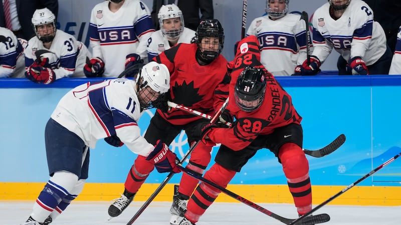 Canada's Micah Zandee-Hart (28) and United States' Abby Roque (11) go for the puck during the...