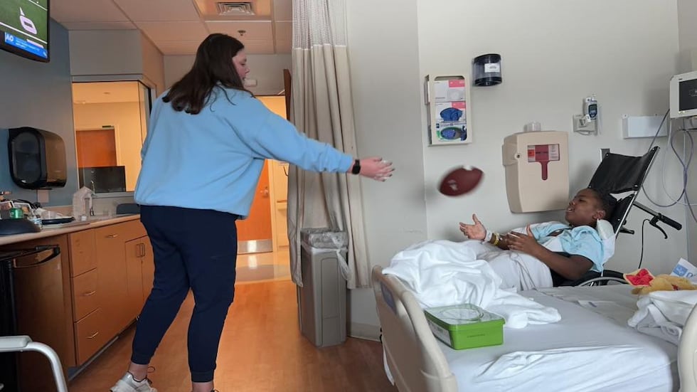 One of the nurses plays catch with young Kaydon Gilliam
