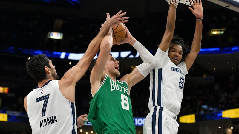 Boston Celtics center Kristaps Porzingis (8) shoots between Memphis Grizzlies forwards Santi...